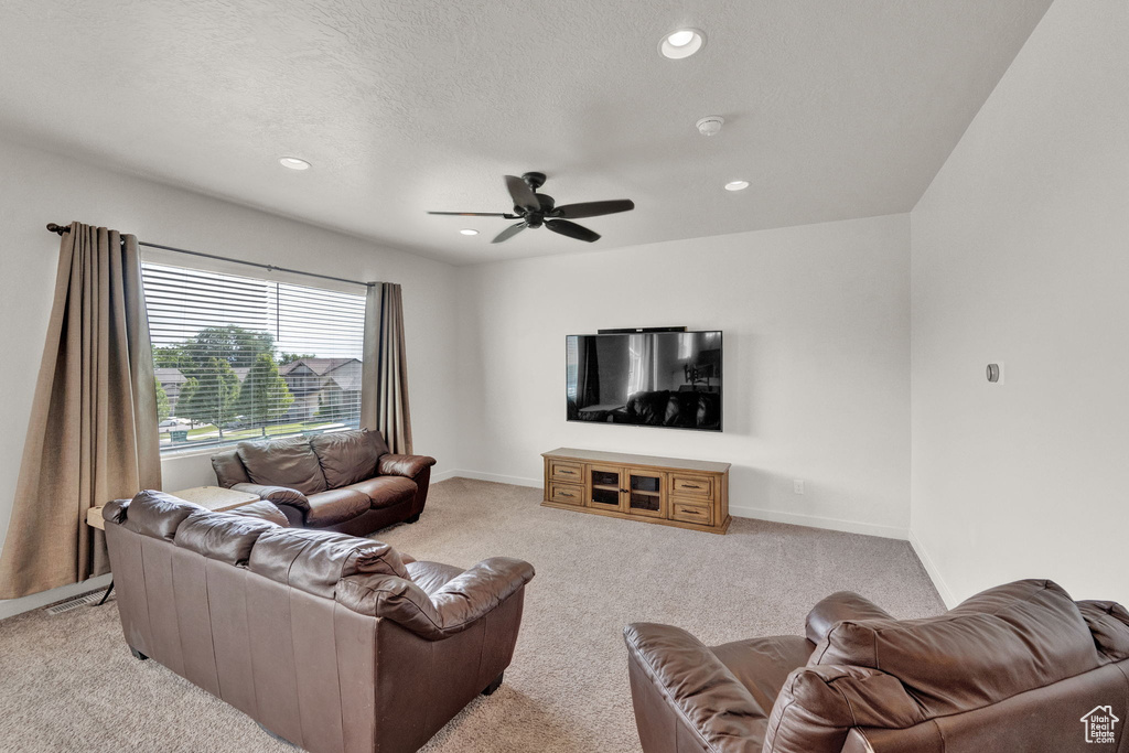 Carpeted living room featuring ceiling fan