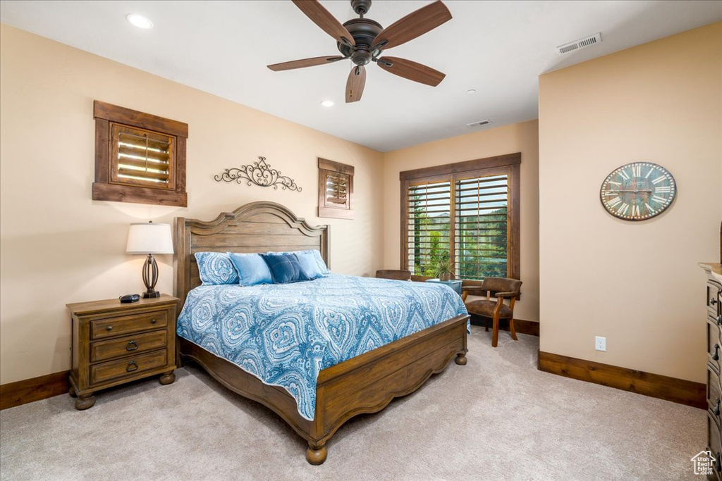 Carpeted bedroom featuring ceiling fan