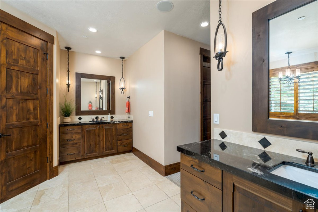 Bathroom featuring a notable chandelier, tile flooring, and vanity