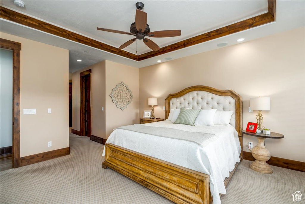 Bedroom featuring carpet flooring, ceiling fan, and a tray ceiling