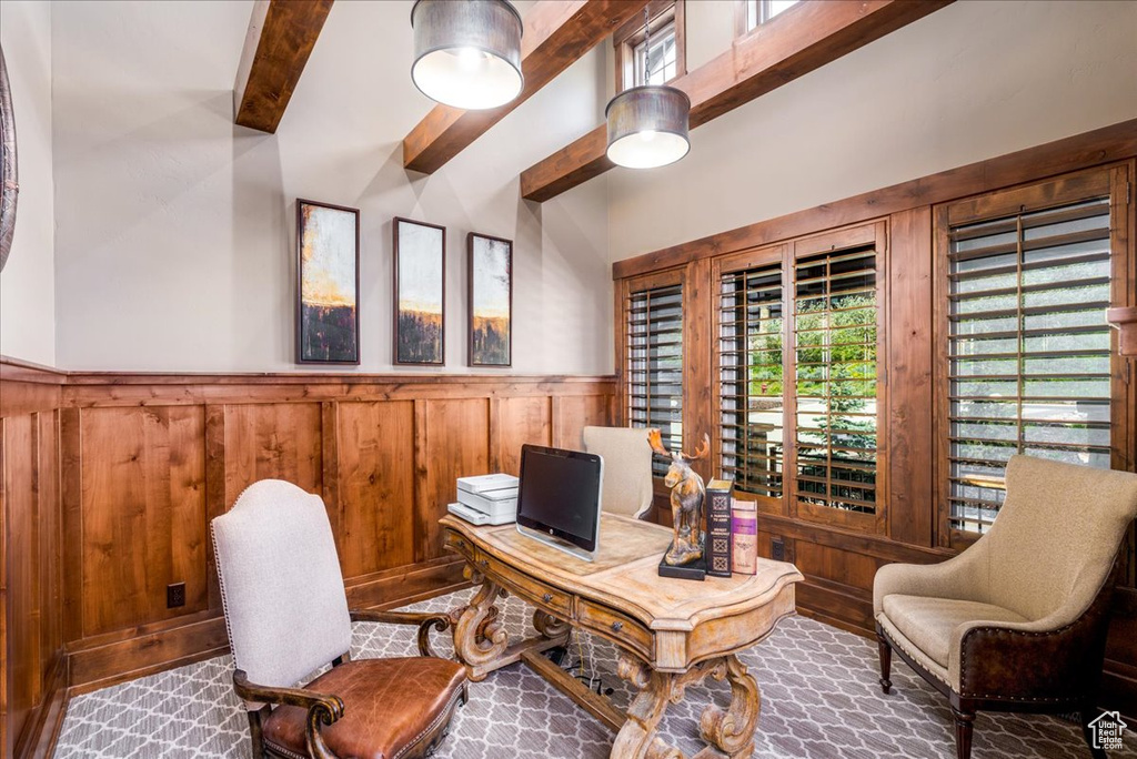 Home office featuring beam ceiling and wood walls