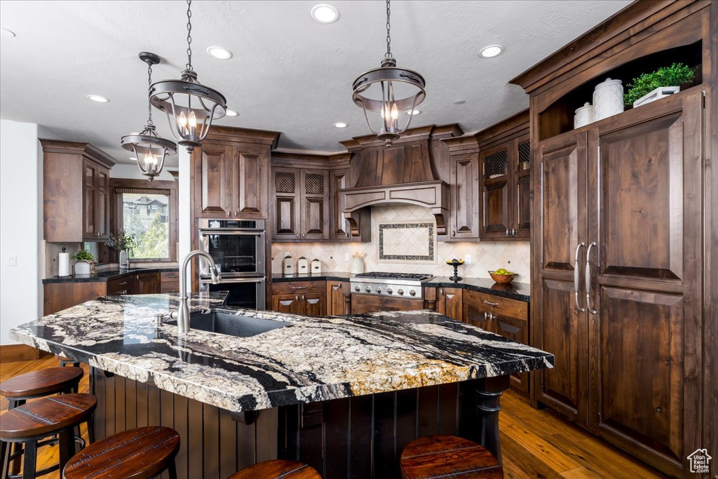 Kitchen with a spacious island, decorative light fixtures, and appliances with stainless steel finishes