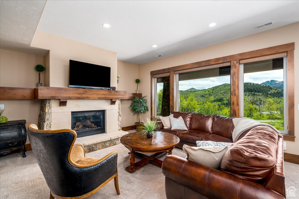 Living room with carpet flooring, a fireplace, plenty of natural light, and a mountain view