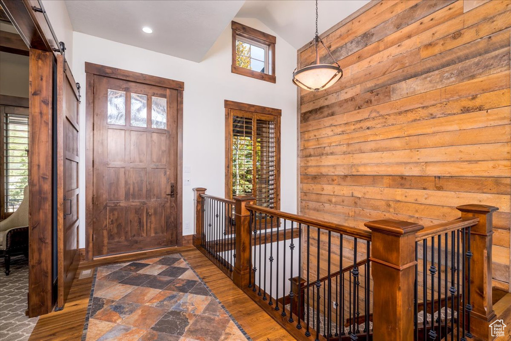 Entryway with a wealth of natural light, hardwood / wood-style flooring, and lofted ceiling