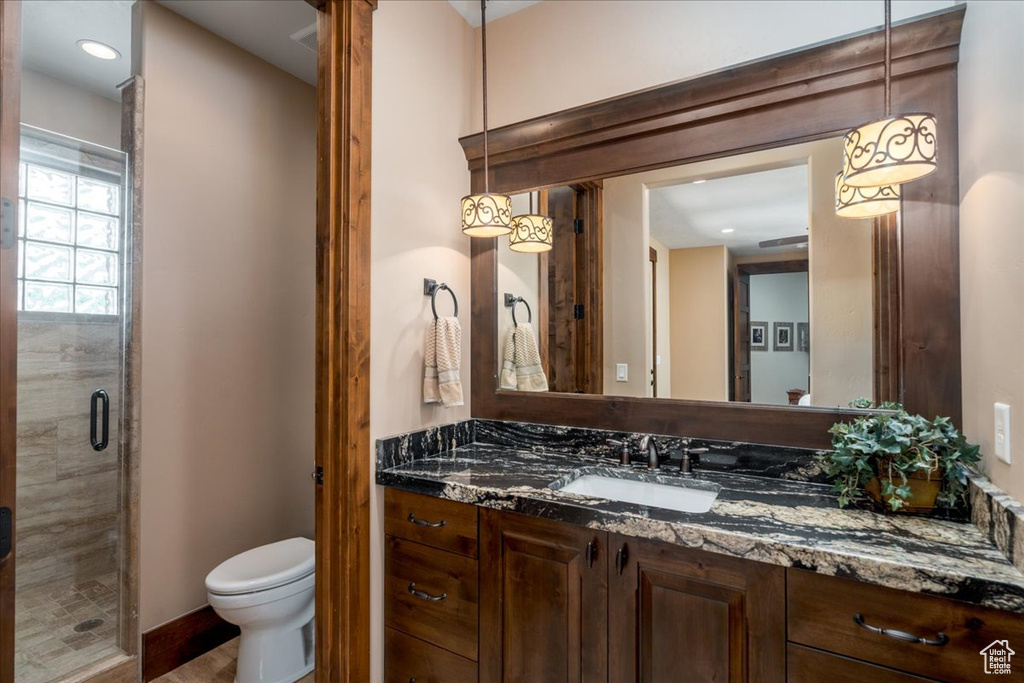 Bathroom with a shower with door, toilet, and vanity