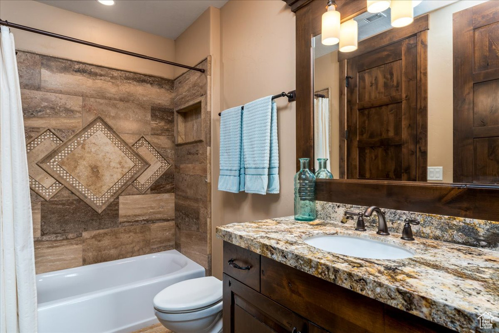 Full bathroom featuring shower / bathtub combination with curtain, vanity, and toilet