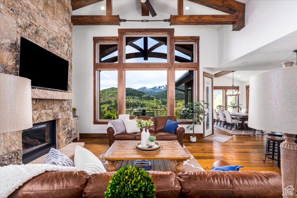 Living room with high vaulted ceiling, a fireplace, wood-type flooring, and a mountain view