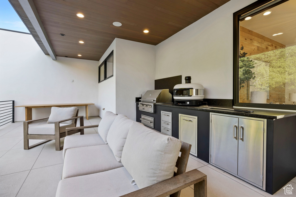 View of patio / terrace featuring a grill, an outdoor hangout area, and an outdoor kitchen