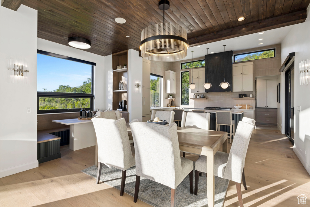 Dining space featuring light hardwood / wood-style floors, a wealth of natural light, wood ceiling, and radiator heating unit