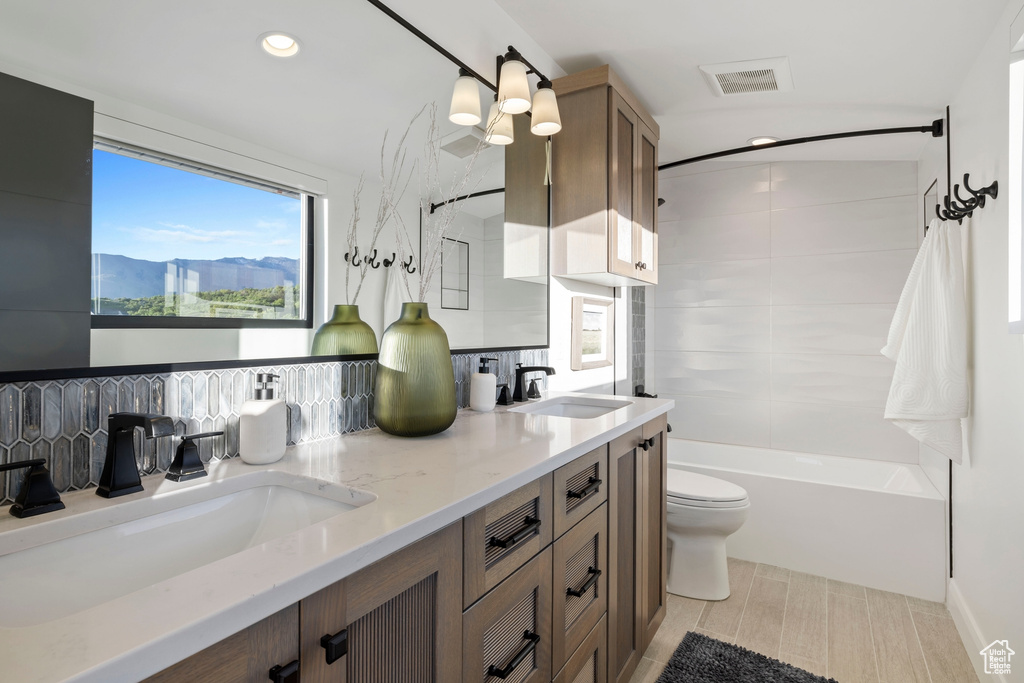 Full bathroom featuring a mountain view, tiled shower / bath combo, tile floors, dual bowl vanity, and toilet