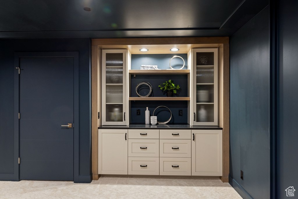 Bar featuring light colored carpet and white cabinets