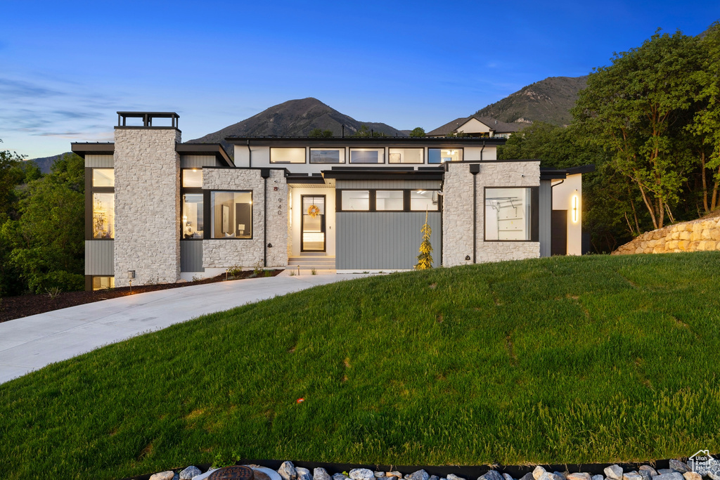 View of front of home with a yard and a mountain view