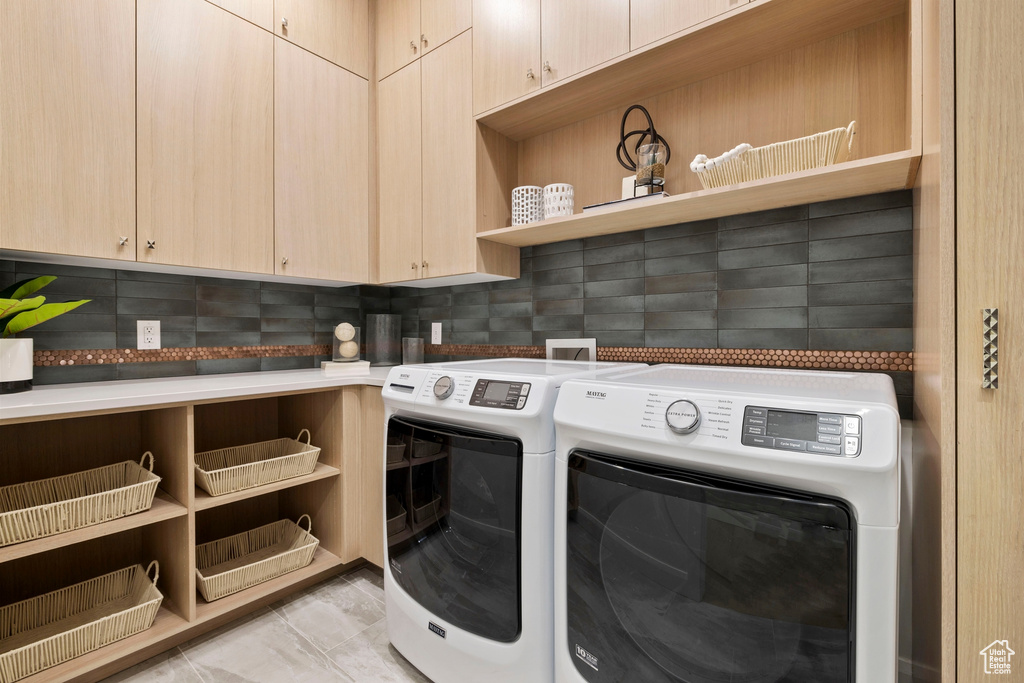 Laundry area with washer and clothes dryer, cabinets, and light tile floors