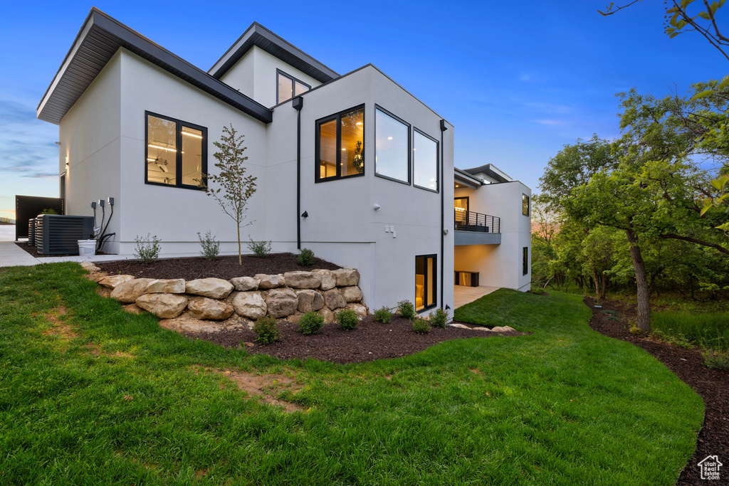 Exterior space with a front yard, central air condition unit, and a balcony