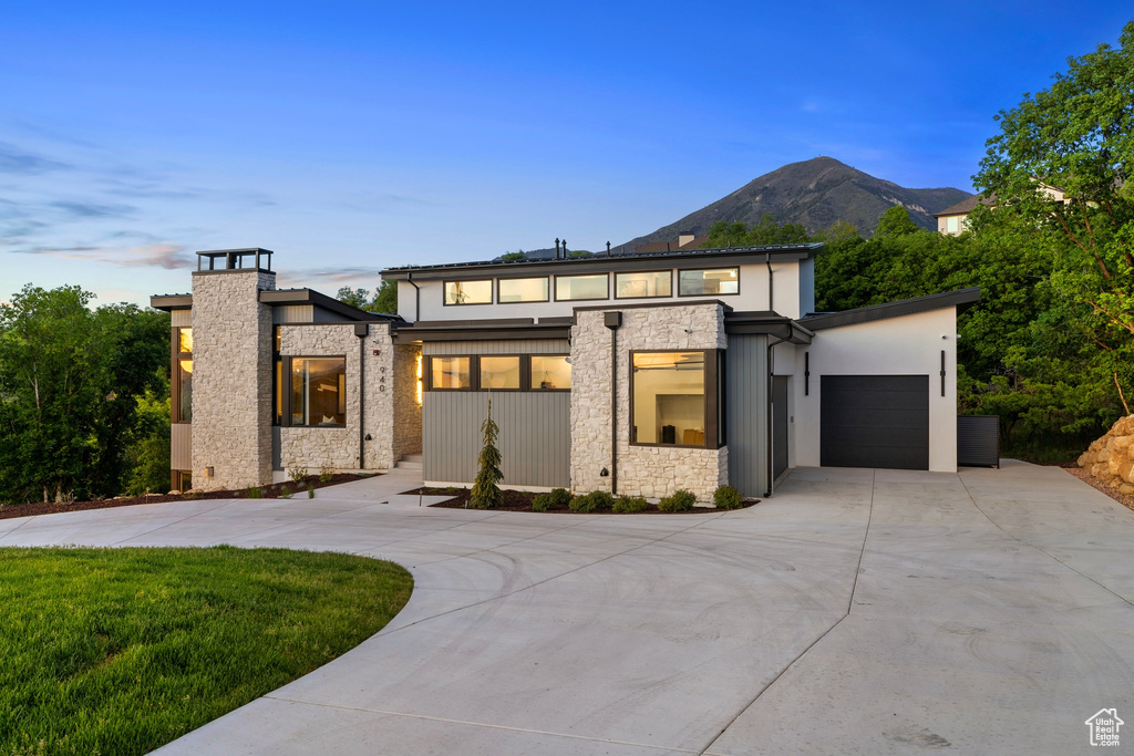 View of front facade with a garage and a mountain view