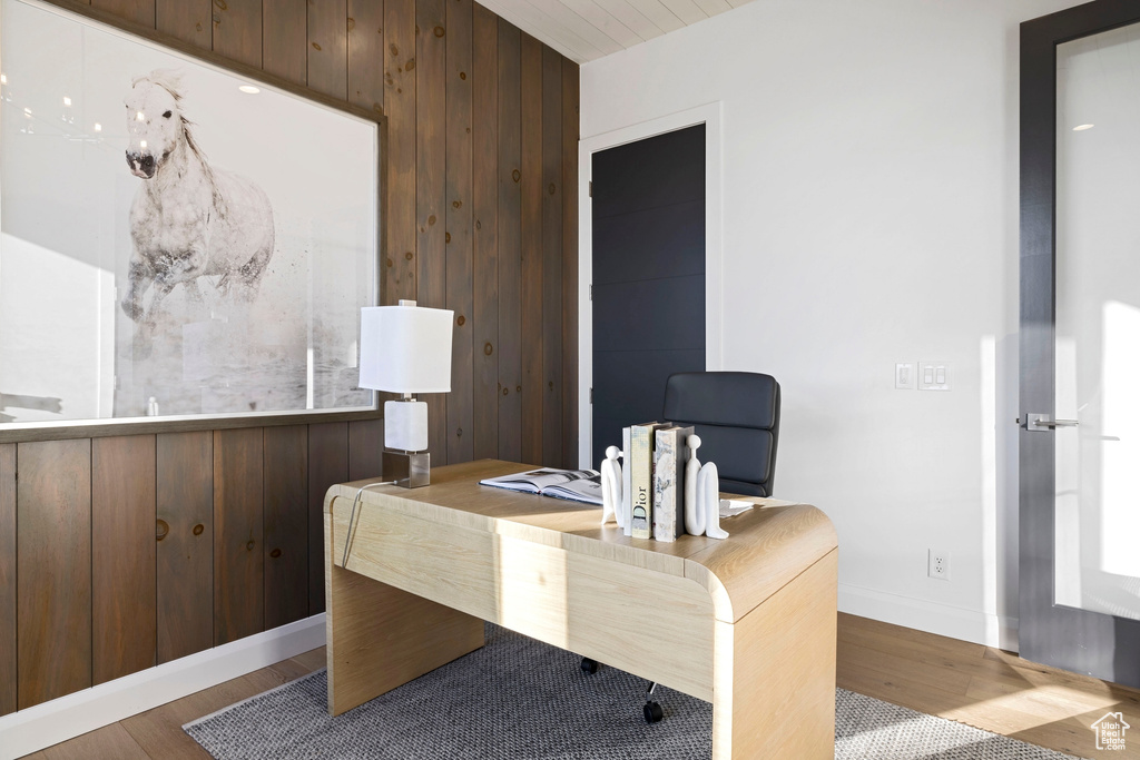 Office with wooden walls and light wood-type flooring