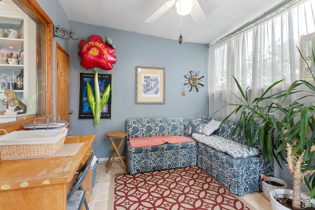 Living room featuring ceiling fan and light tile flooring