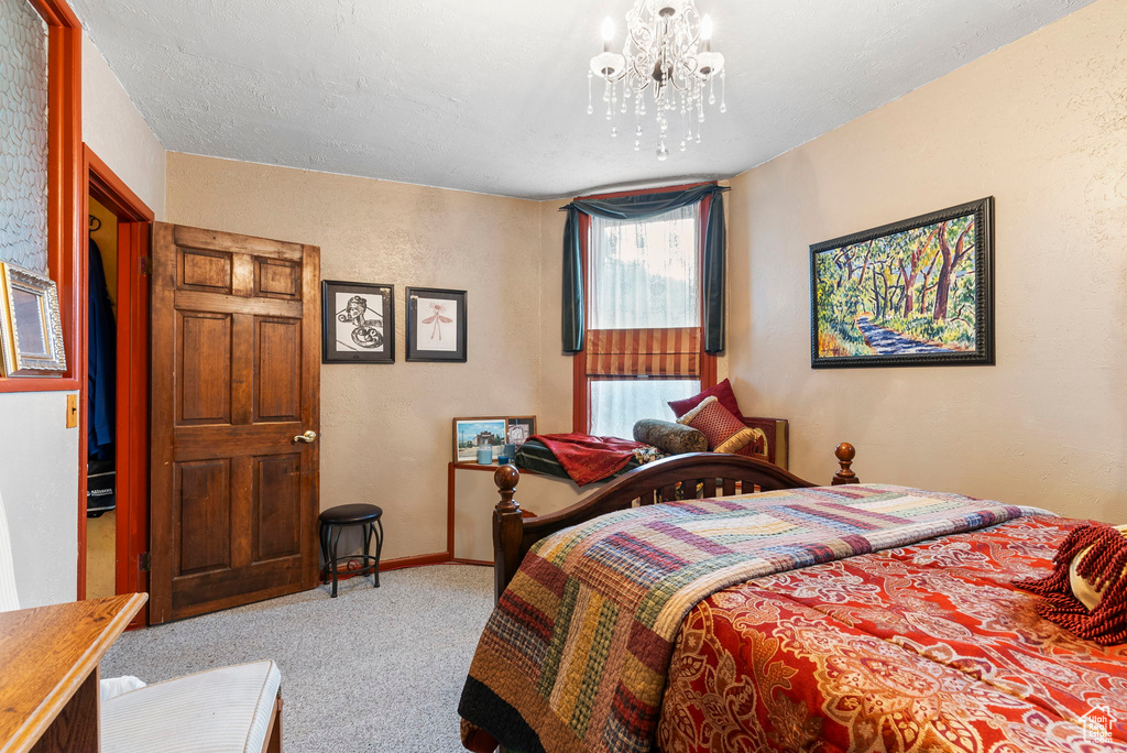 Bedroom featuring an inviting chandelier and carpet