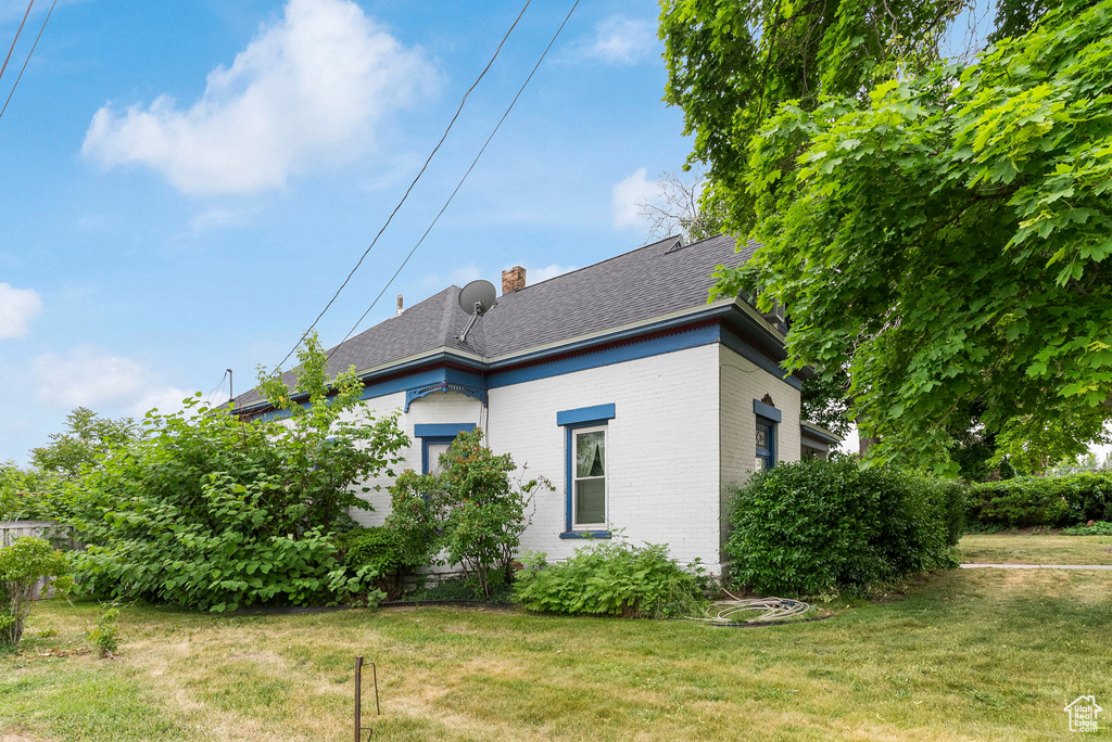 Rear view of house featuring a lawn