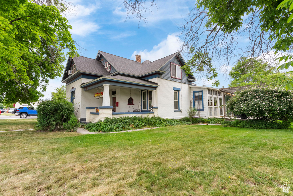 Exterior space with covered porch and a lawn