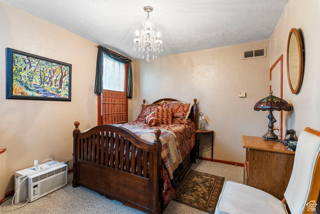 Bedroom with light colored carpet, an inviting chandelier, and a textured ceiling