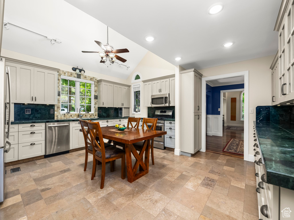 Interior space with ceiling fan, lofted ceiling, and sink