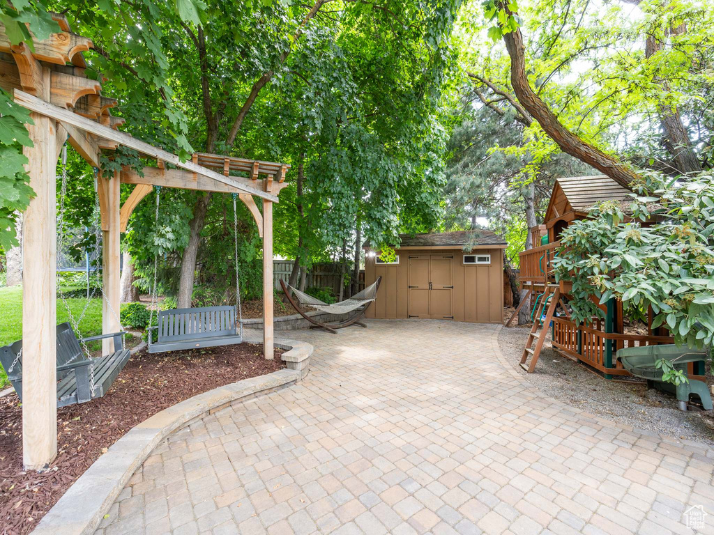 View of terrace featuring a pergola and a storage shed