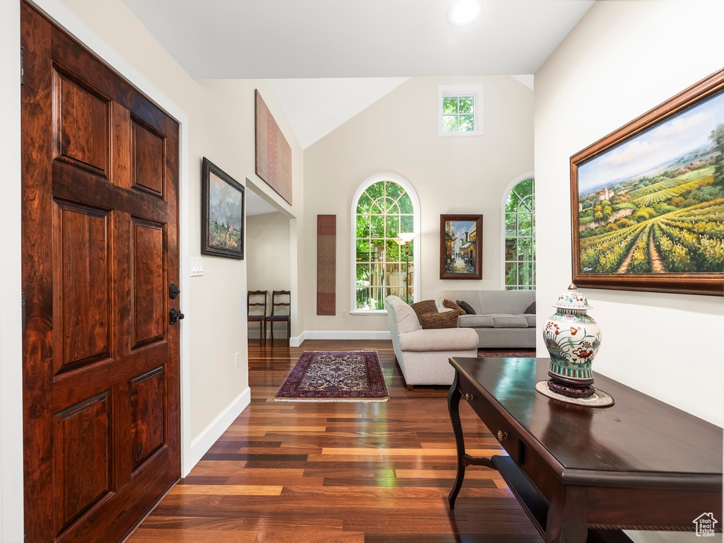 Living room with high vaulted ceiling and dark hardwood / wood-style floors