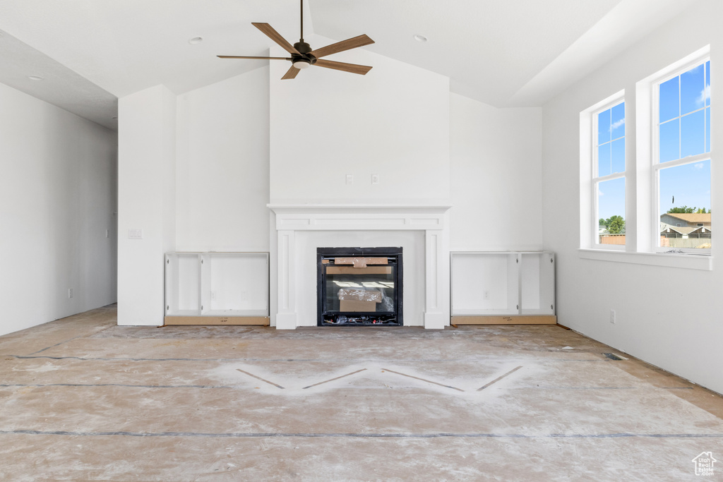 Unfurnished living room featuring ceiling fan and high vaulted ceiling