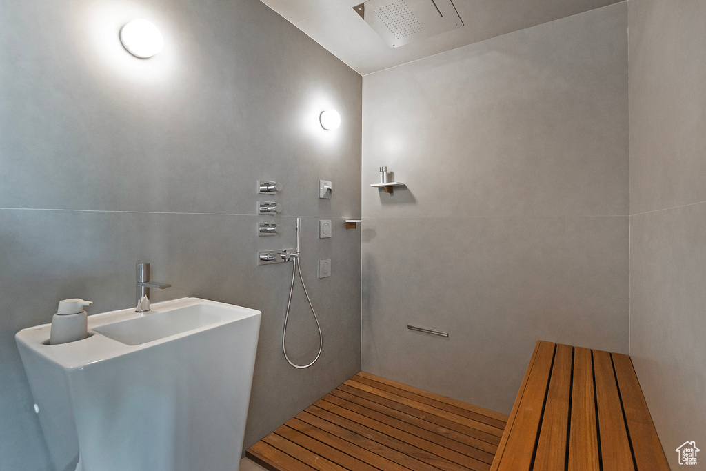 Bathroom featuring walk in shower, hardwood / wood-style flooring, and sink