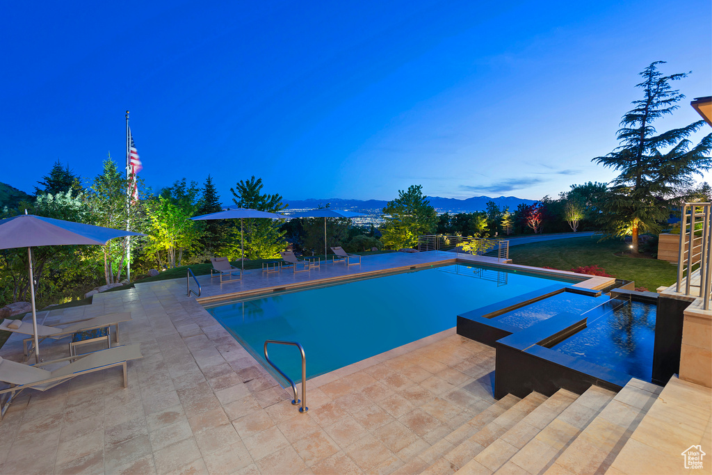 View of pool with a patio and a mountain view