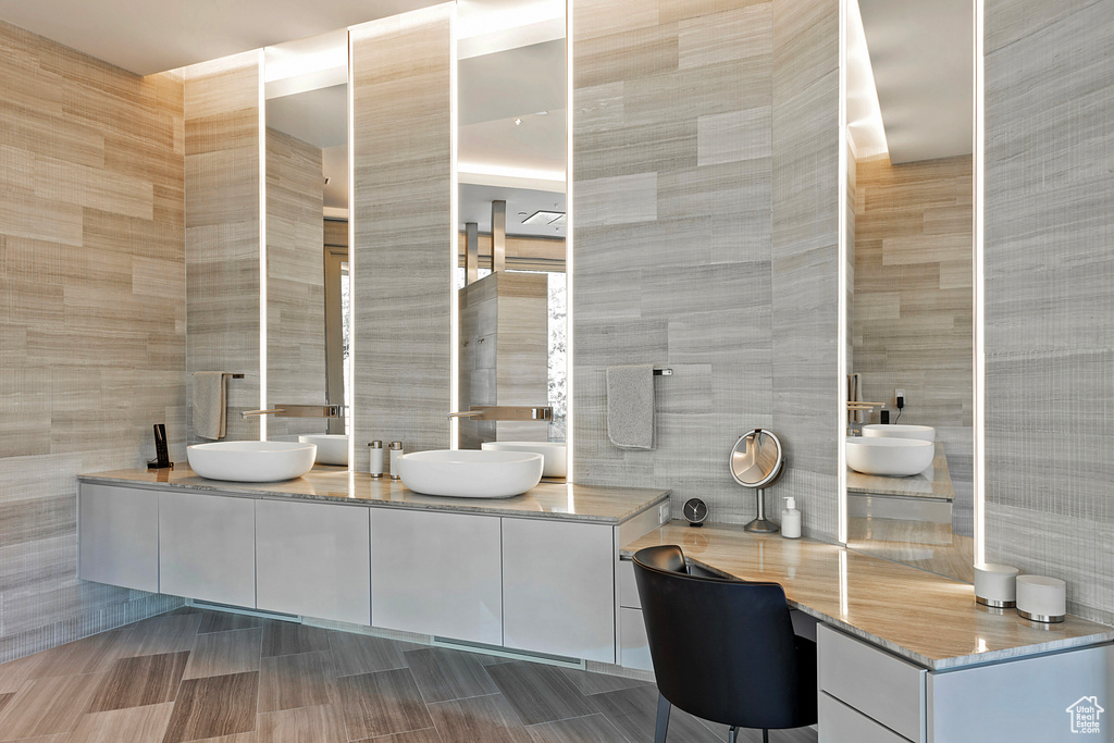 Bathroom with tile walls, tile flooring, and dual vanity