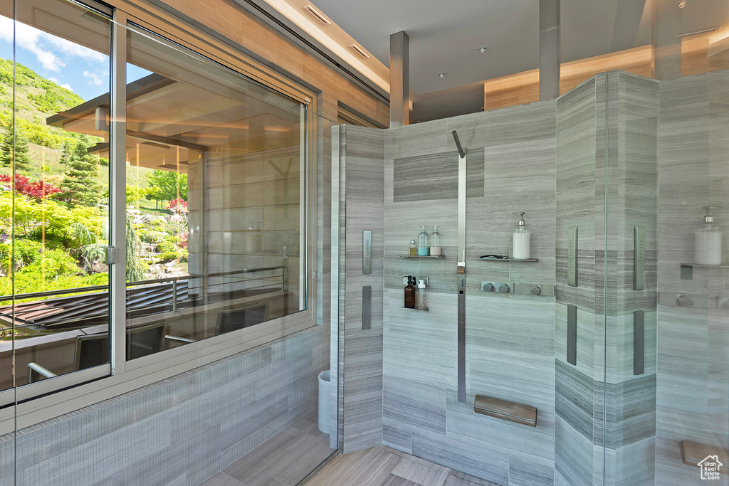 Bathroom with walk in shower and tile walls