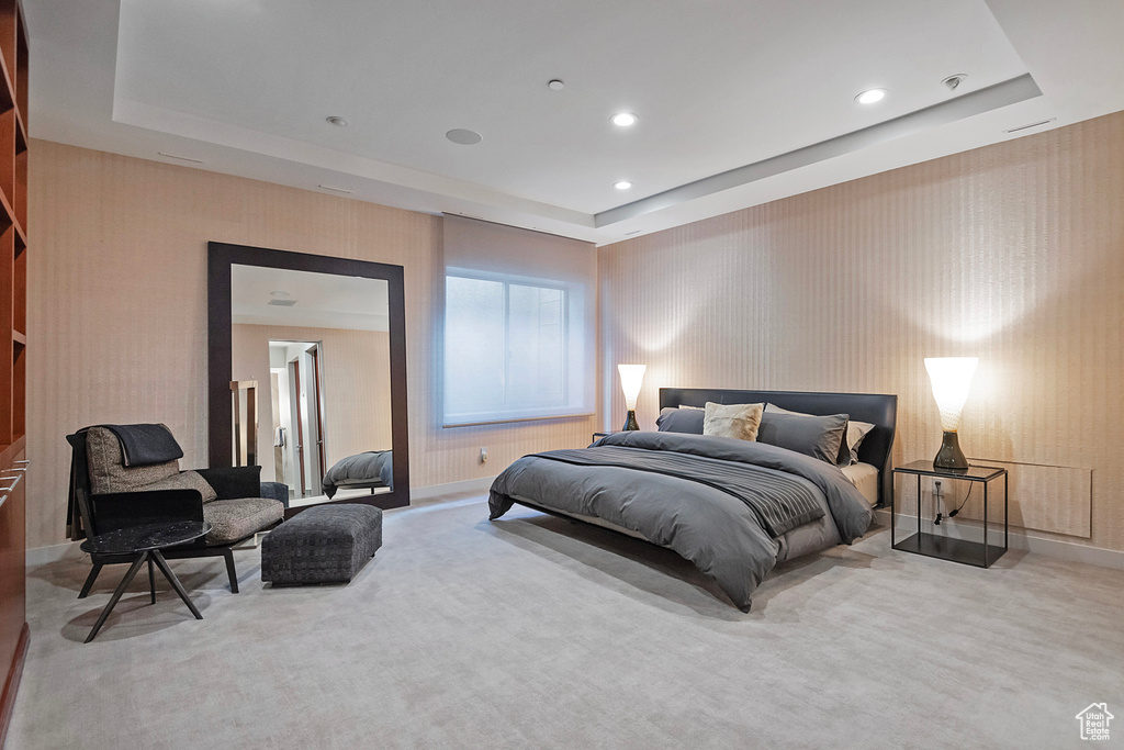 Carpeted bedroom with a tray ceiling