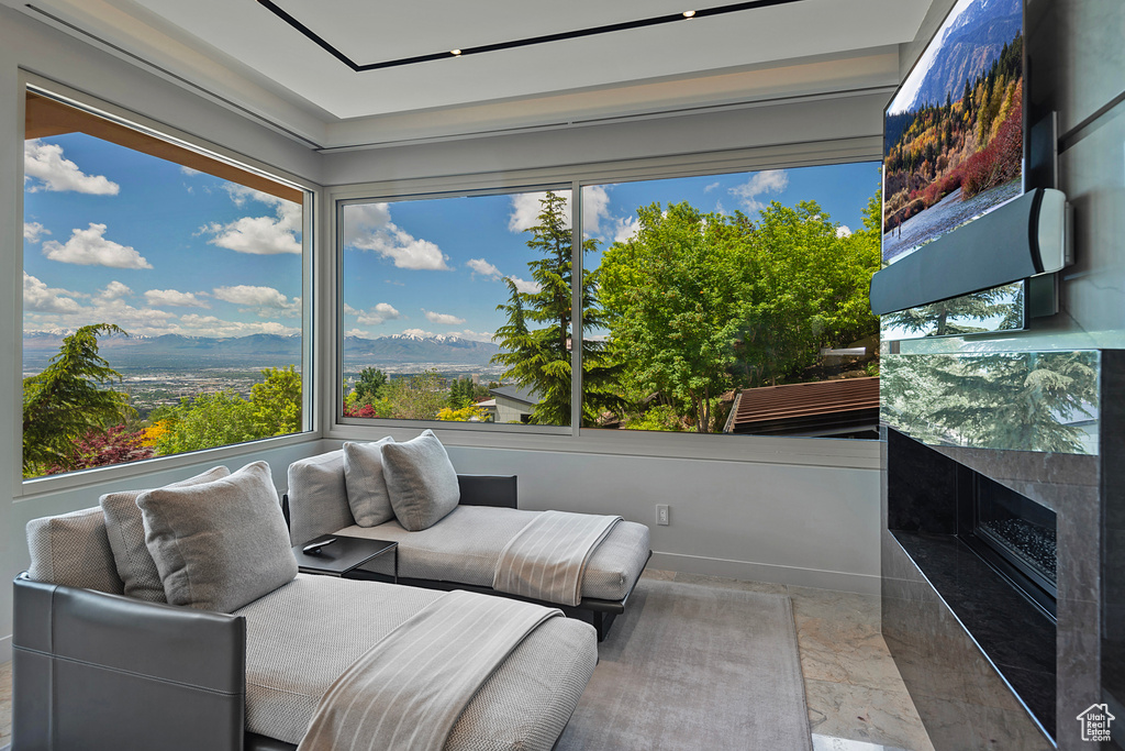 Sunroom with a healthy amount of sunlight, a fireplace, and a mountain view