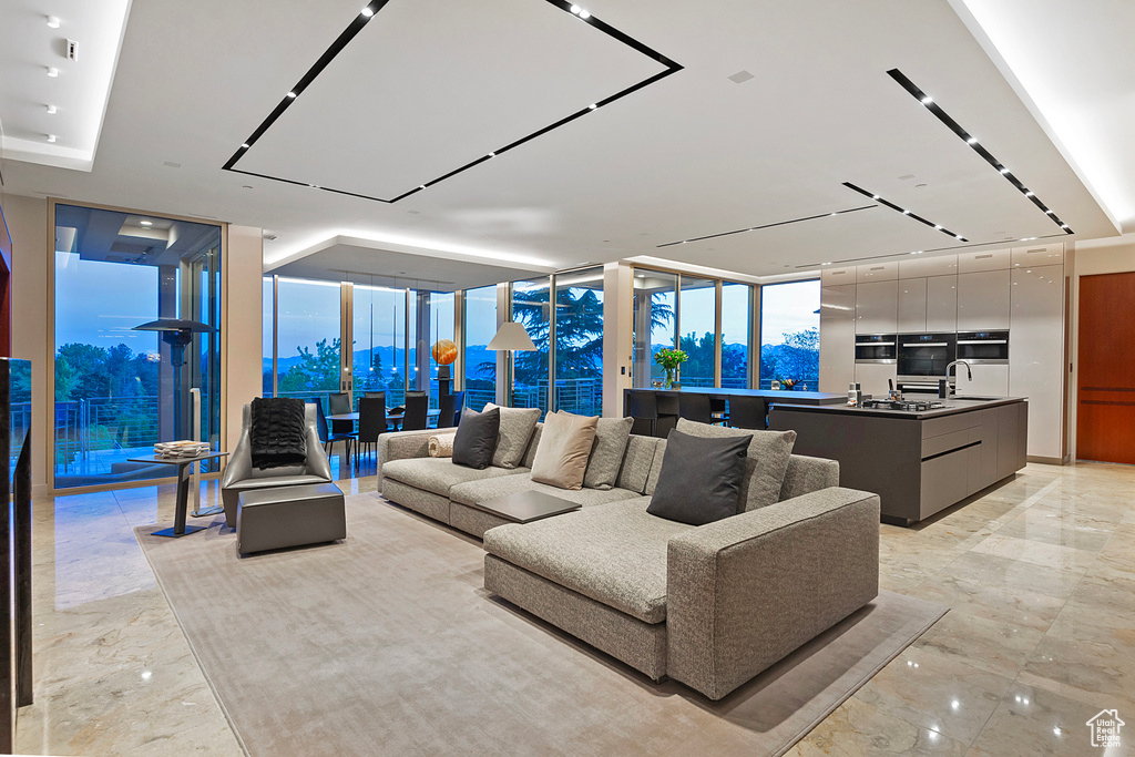 Living room with light tile flooring and a wall of windows