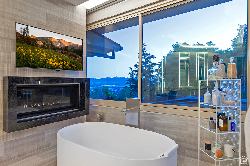 Bathroom with a mountain view, a fireplace, and tile walls