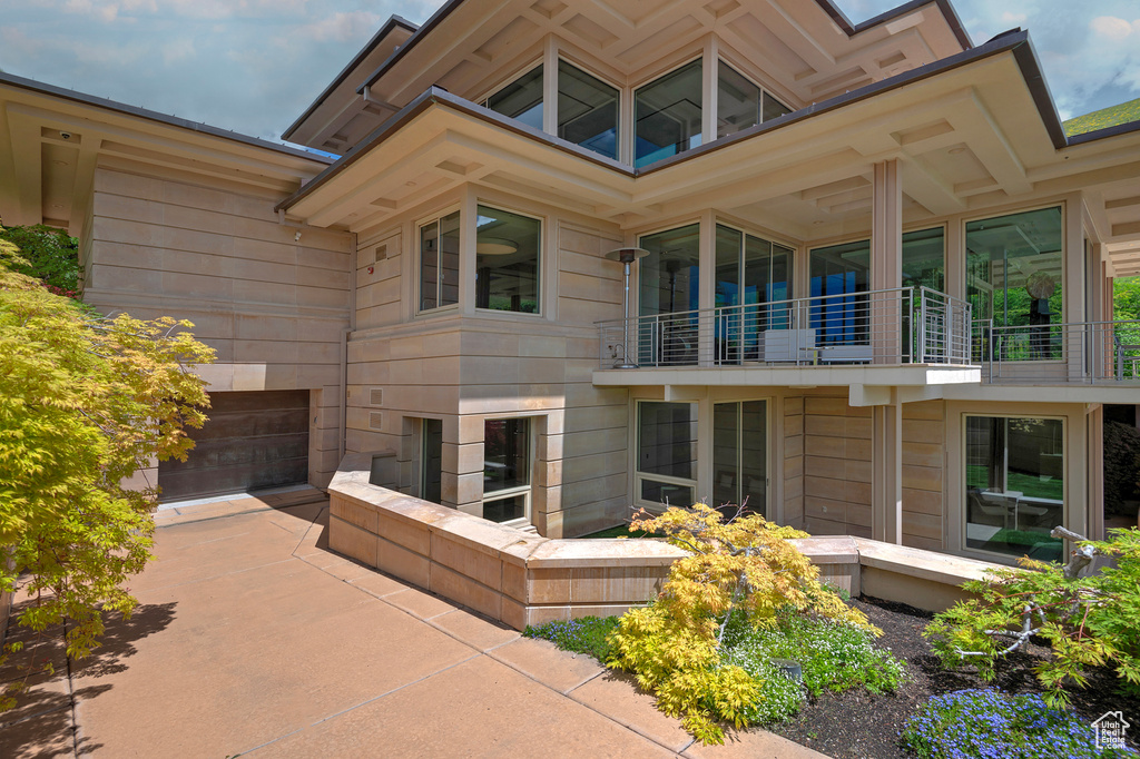 Rear view of house featuring a garage and a balcony