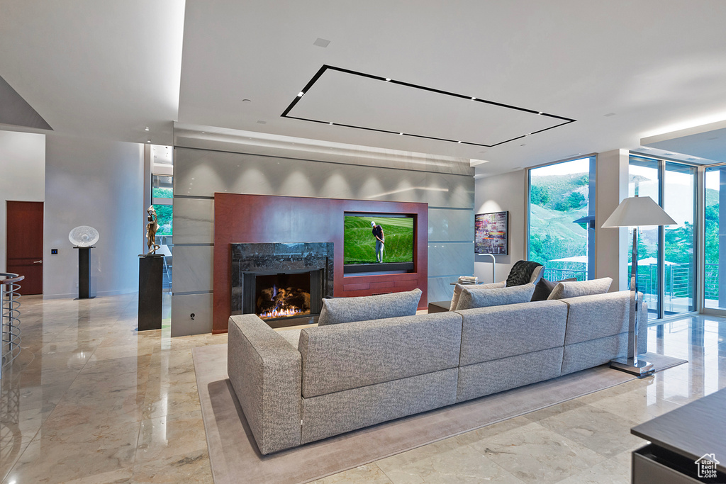 Tiled living room featuring a premium fireplace and floor to ceiling windows