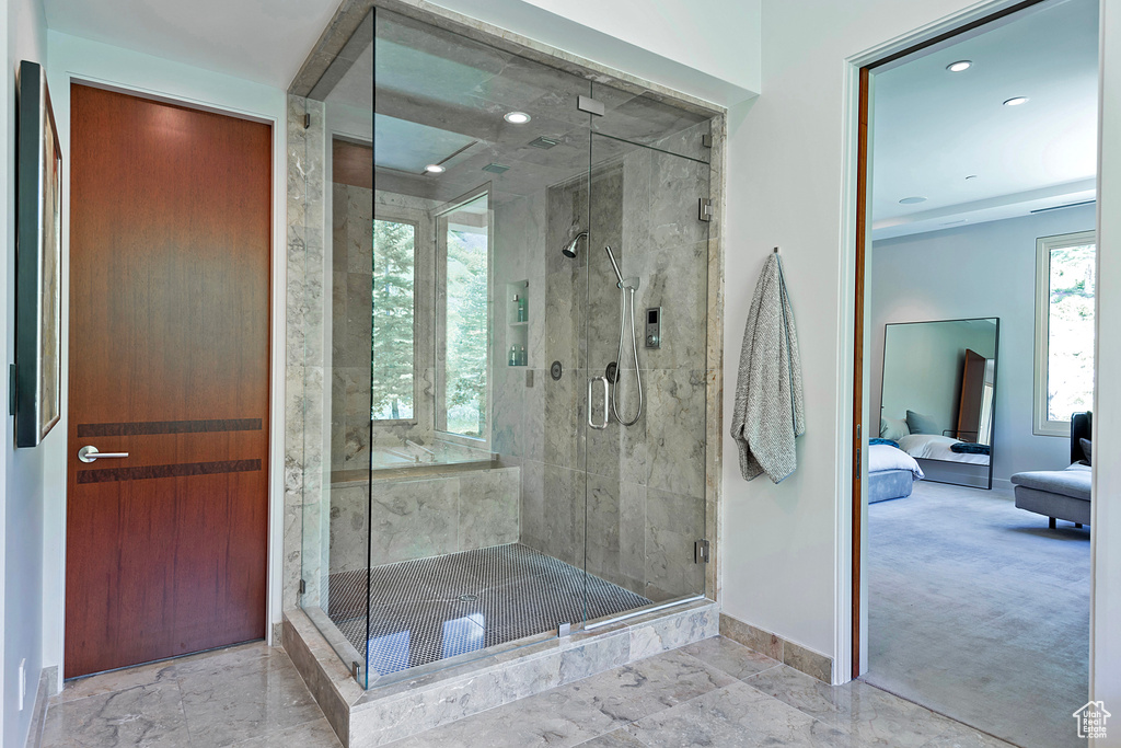 Bathroom with tile flooring and a shower with door