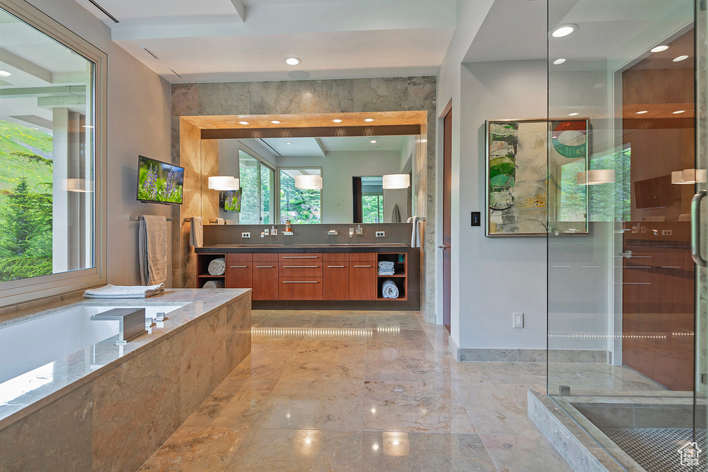 Bathroom with tile flooring, separate shower and tub, and vanity