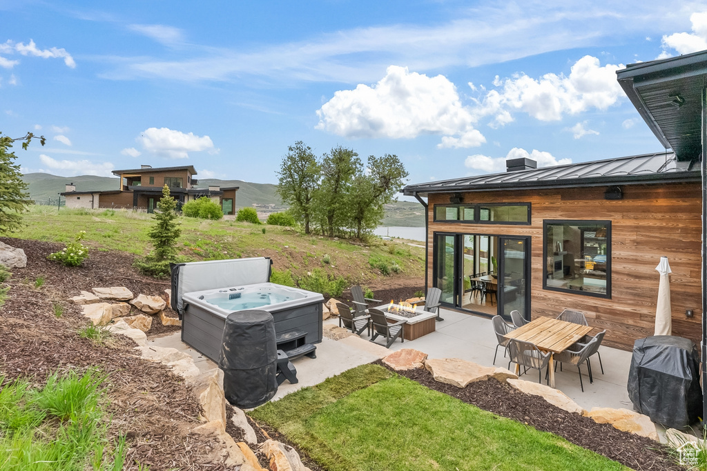 View of yard featuring a hot tub and a patio