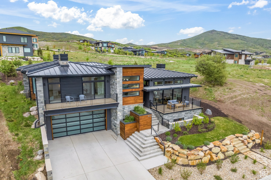 Contemporary house featuring a garage, a mountain view, and a balcony