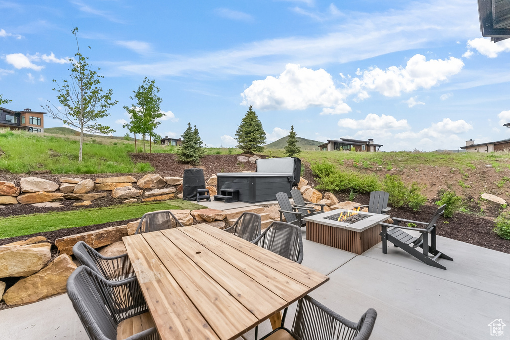 View of terrace with a hot tub and an outdoor fire pit