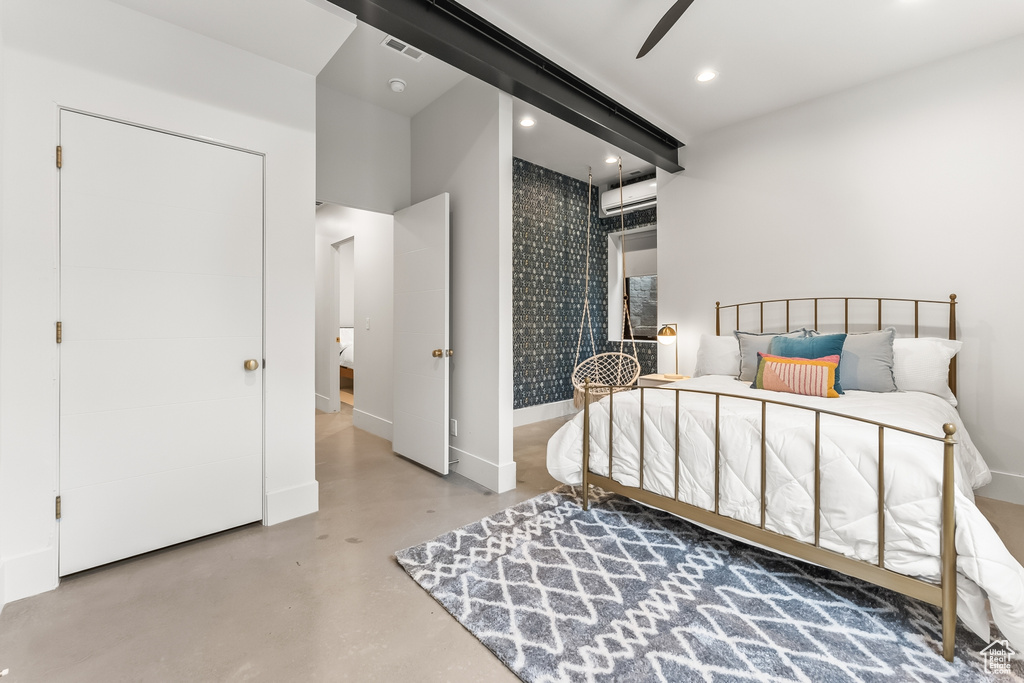 Bedroom featuring ceiling fan, an AC wall unit, and concrete flooring