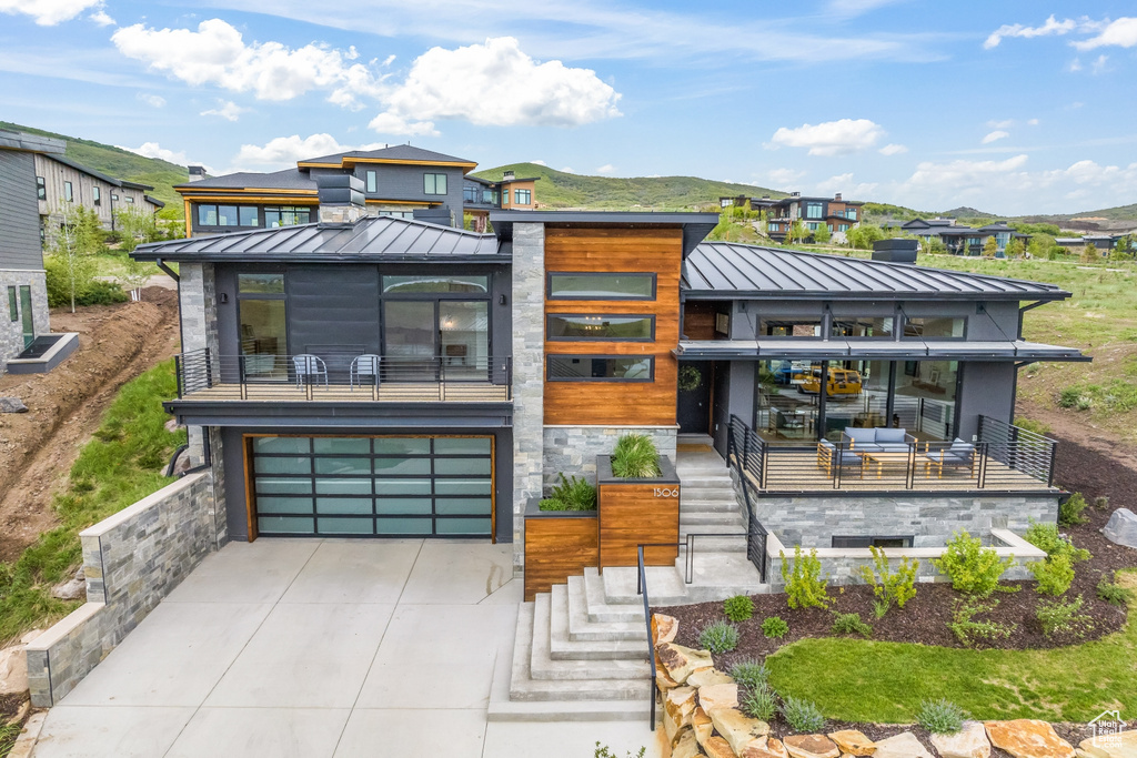 View of front of property with a garage and a balcony