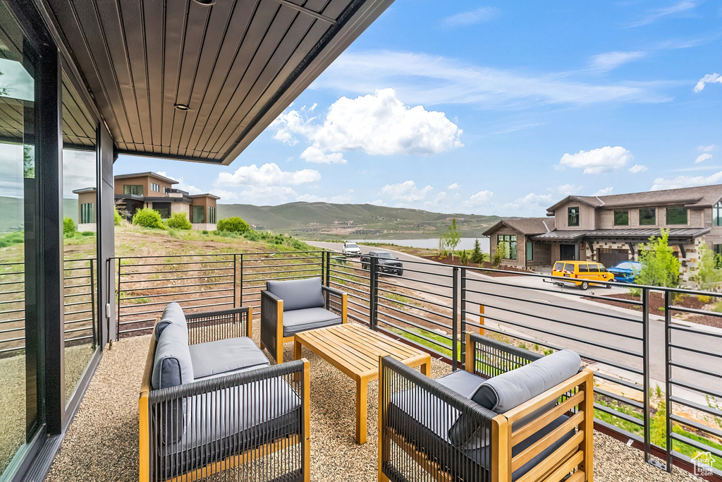 View of patio featuring a mountain view, a balcony, and an outdoor hangout area