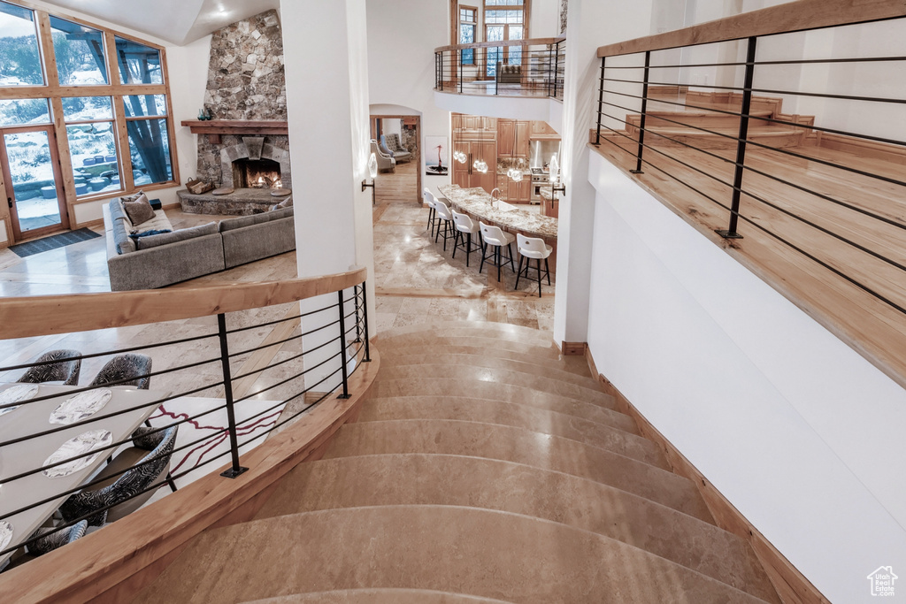 Hallway featuring high vaulted ceiling and tile flooring