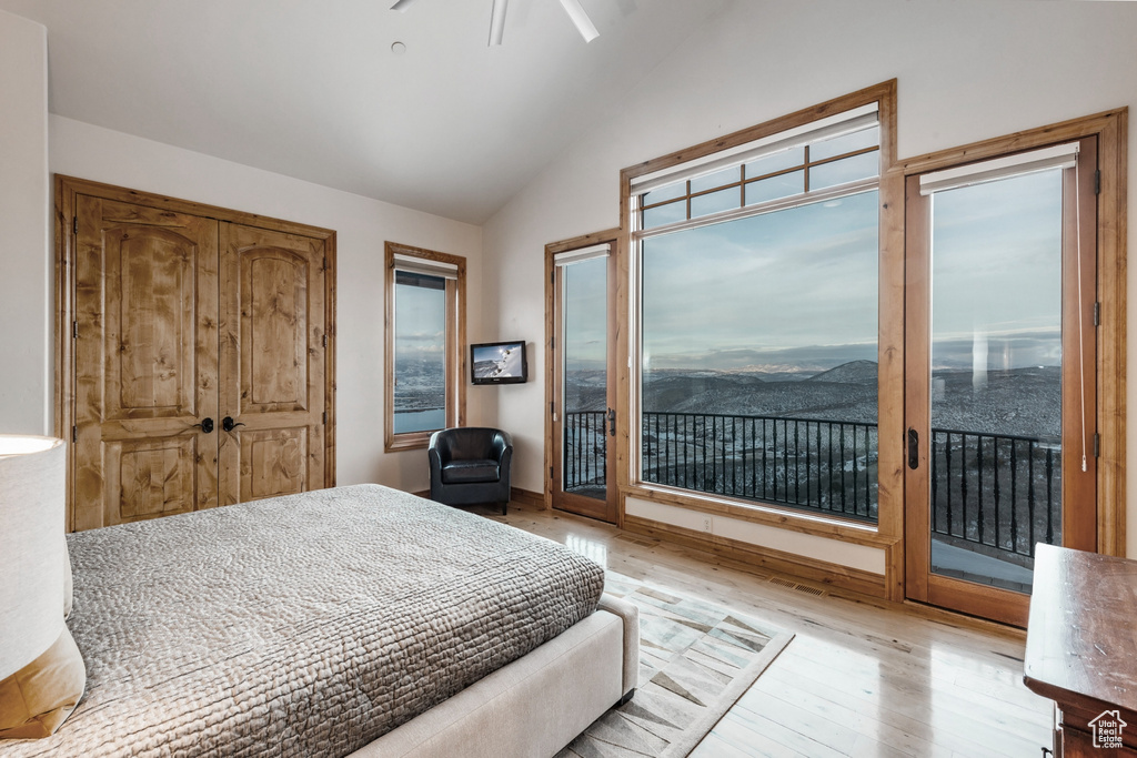 Bedroom with access to exterior, ceiling fan, light wood-type flooring, and lofted ceiling