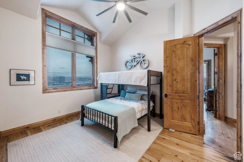 Bedroom with lofted ceiling, light wood-type flooring, and ceiling fan